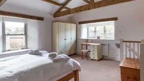 Een slaapkamer met een bed, bureau en een kledingkast.