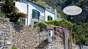 Kivestä rakennettu portaikko johtaa rakennukseen, jonka yläpuolella on kyltti, jossa lukee: ”Casa Le Calle Positano”.