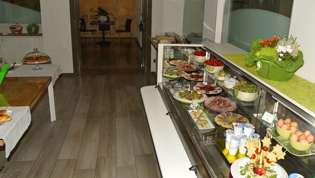 Un bufé con diferentes opciones de comida y un área de estar al fondo.