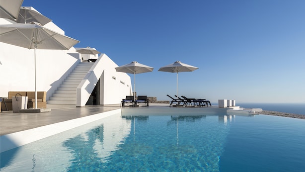 A infinity pool with clear blue water, white architecture, and outdoor seating with umbrellas. - La Maltese Villas Santorini (Santorini)