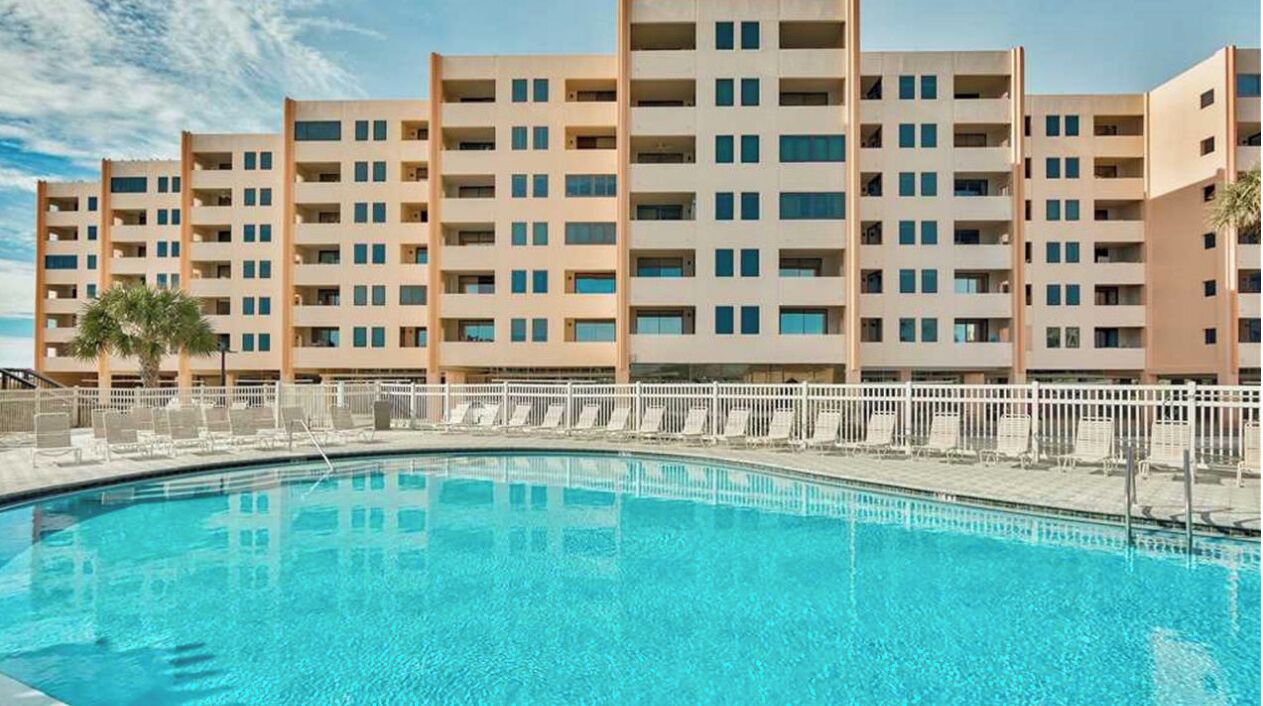 Une piscine avec un bâtiment moderne en arrière-plan.