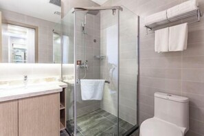 A modern bathroom with a glass shower enclosure, a toilet, and a vanity with a mirror. - Fengze Business Hotel (Fanshi)