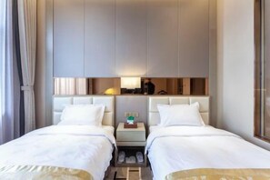 A hotel room with two beds, a nightstand with a lamp, and a mirror above the beds. - Fengze Business Hotel (Fanshi)