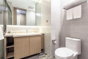 A modern bathroom with a toilet, sink, and mirror. - Fengze Business Hotel (Fanshi)