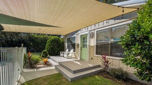 A house with a covered patio, a front door, and a small garden area.