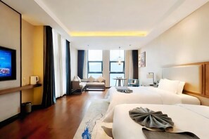 A hotel room with two beds, a TV, a sofa, a small table, and a view of the sea. - Zhongyi Hotel (Zhong County)