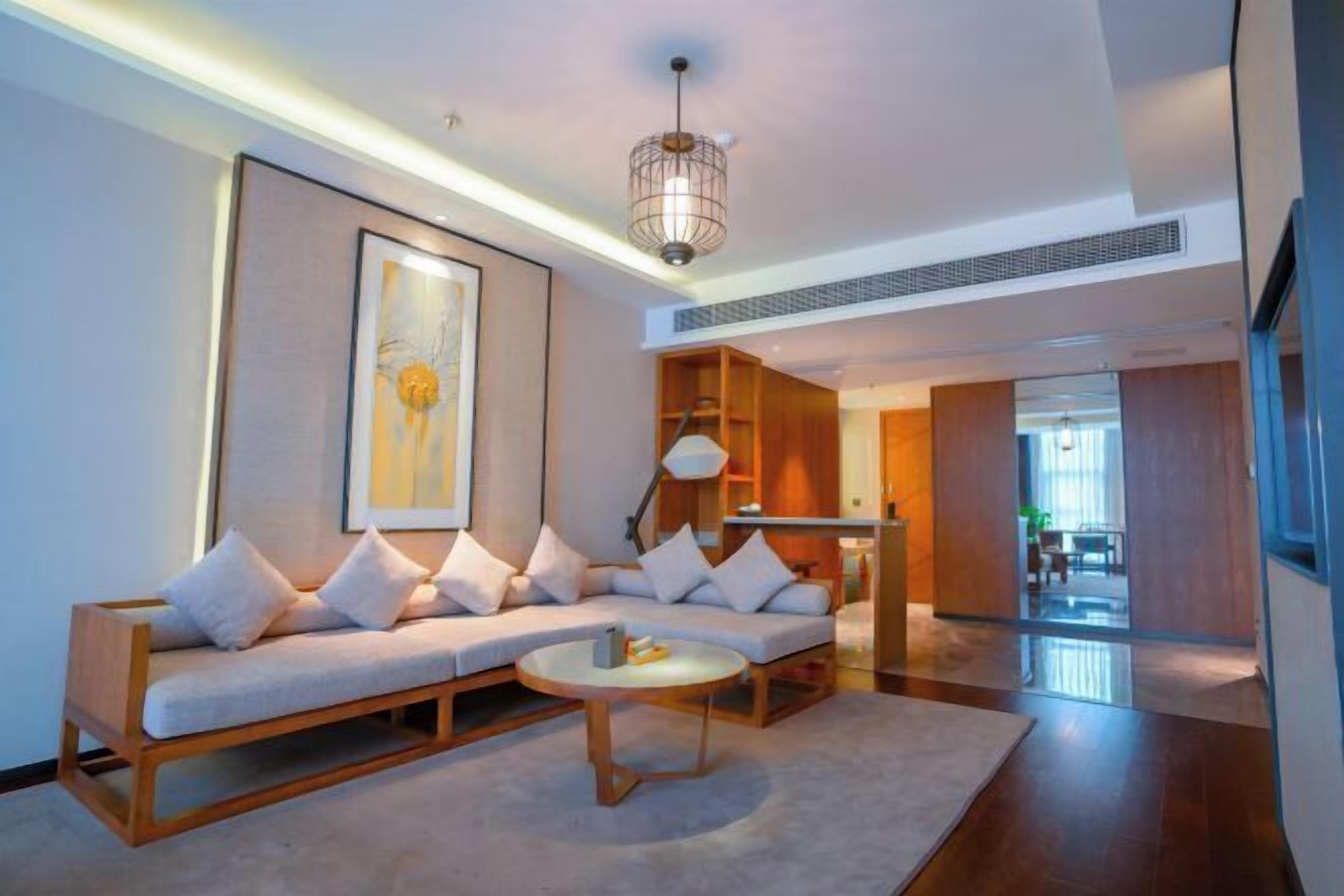 A modern living room with a sofa, coffee table, and artwork on the wall.