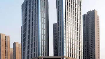 A high-rise building with a modern architectural design, featuring a prominent glass facade and a central entrance.