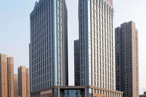 A high-rise building with a modern architectural design, featuring a prominent glass facade and a central entrance. - Nanting International Hotel (Changsha)