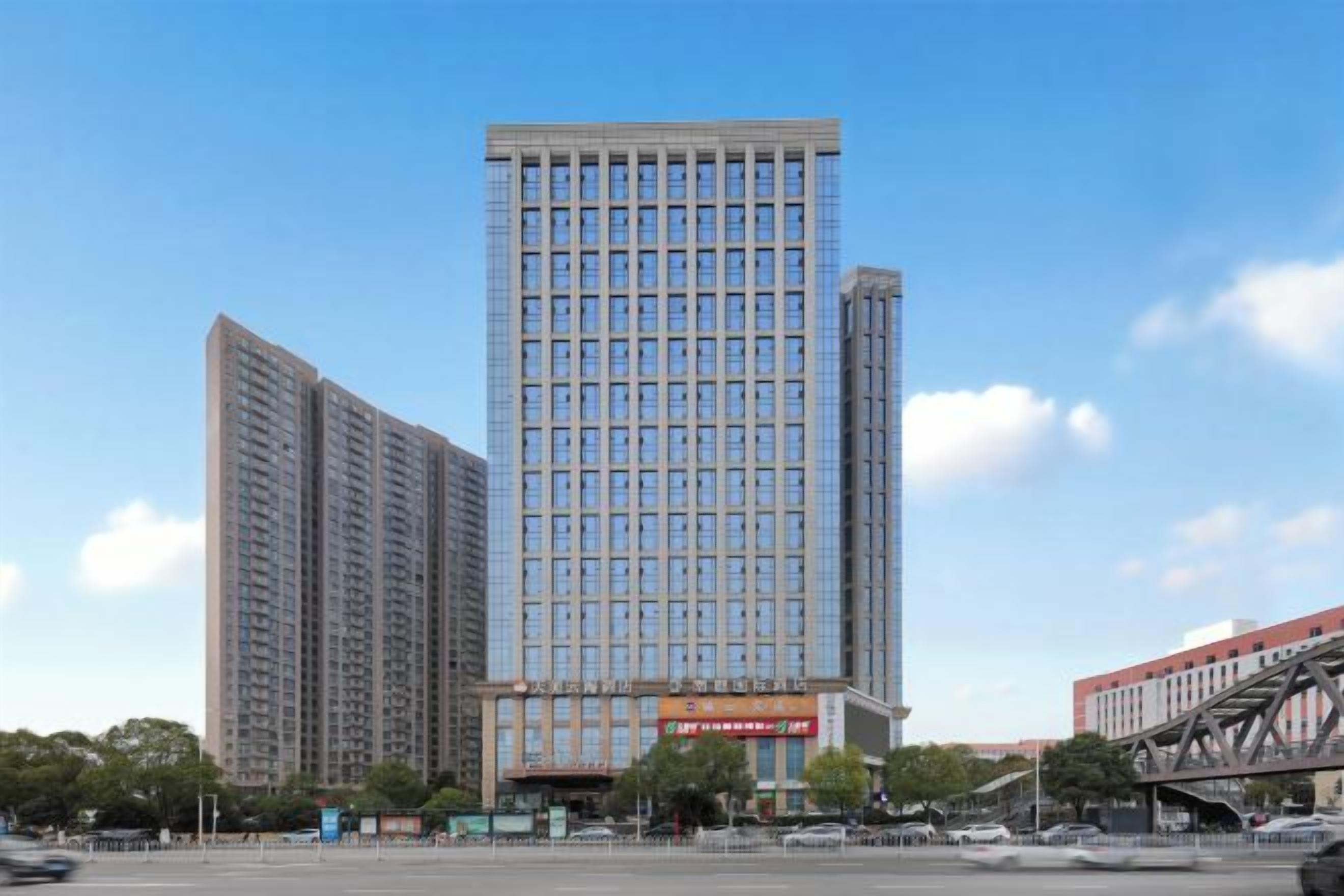 A high-rise building with a modern glass facade, multiple floors, and a prominent entrance with signage.