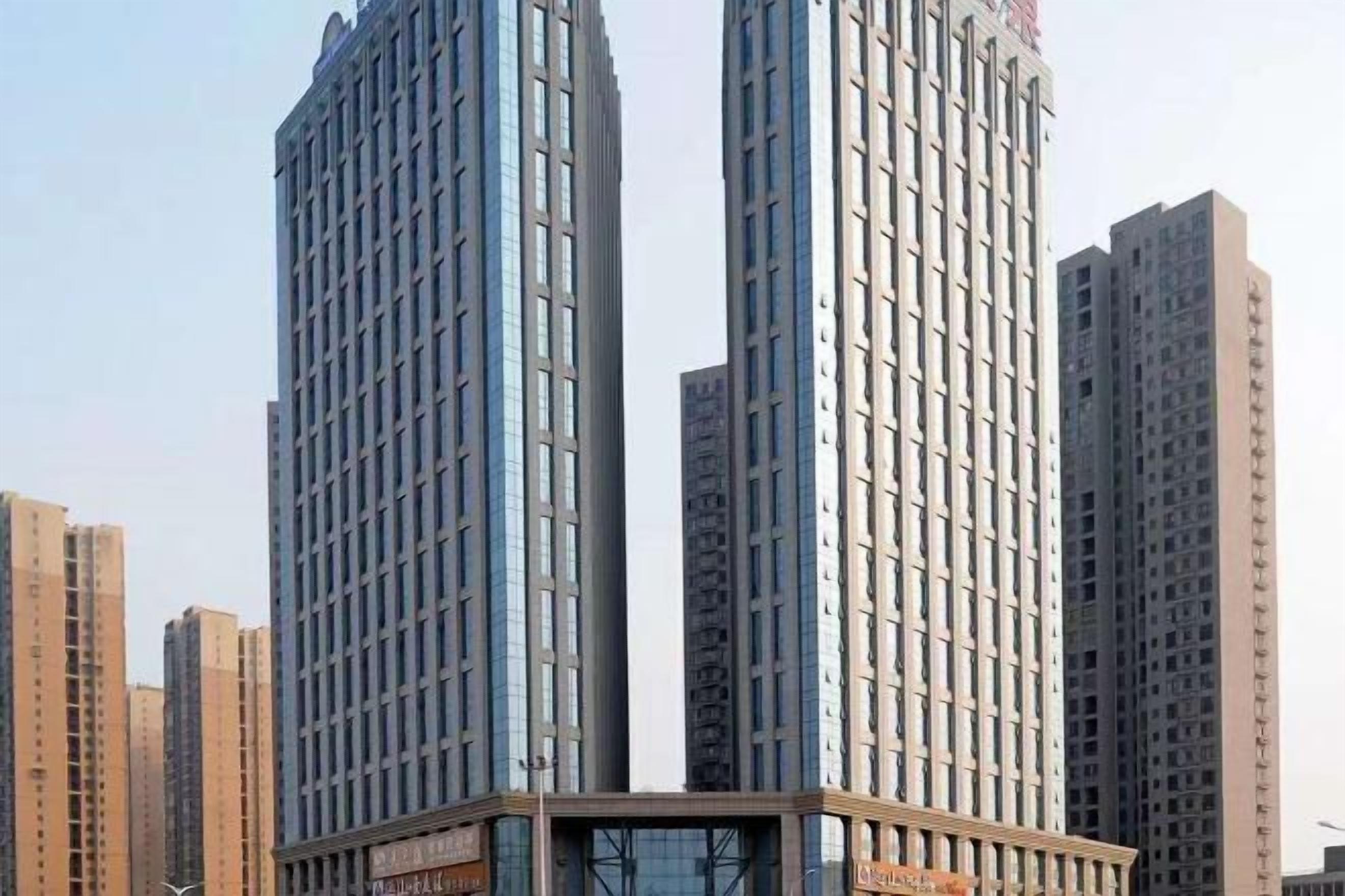 A high-rise building with a modern architectural design, featuring a prominent glass facade and a central vertical element.