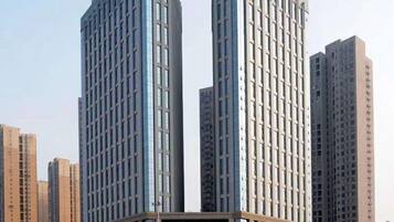 A high-rise building with a modern architectural design, featuring a prominent glass facade and a central vertical element.