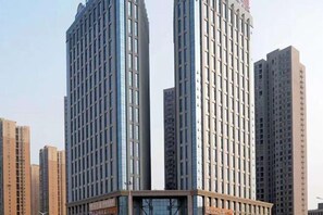 A high-rise building with a modern architectural design, featuring a prominent glass facade and a central vertical element.