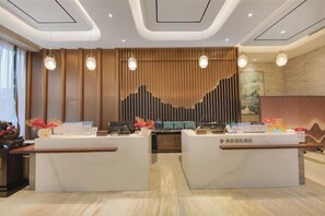 A reception area with two counters, a wooden panel wall, and pendant lighting. - Nanting International Hotel (Changsha)