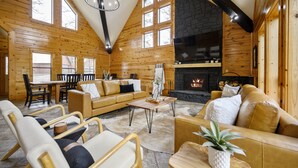 Een blokhutinterieur met een open haard, houten wanden en een gezellige zithoek.