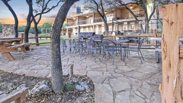 An outdoor patio area with stone flooring, metal chairs, and a barbecue grill. - Private Lakeview Resort/Sleeps up to 25/Pet Friendly/Walking Distance to Lake (Canyon Lake)