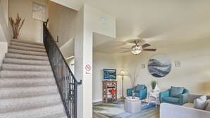 A staircase with a banister, a living room with a ceiling fan, a 'No Smoking' sign, and a beach-themed rug. - Private Lakeview Resort/Sleeps up to 25/Pet Friendly/Walking Distance to Lake (Canyon Lake)