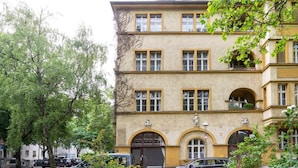 A multi-story building with a classic architectural style, featuring arched windows and a central entrance. - Stylish Loft Apartment (Berlin)