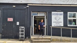 A black building with a sign for 'Westmere Sea Oyster Bar' and a 'Strictly No Parking Keep Clear' sign.
