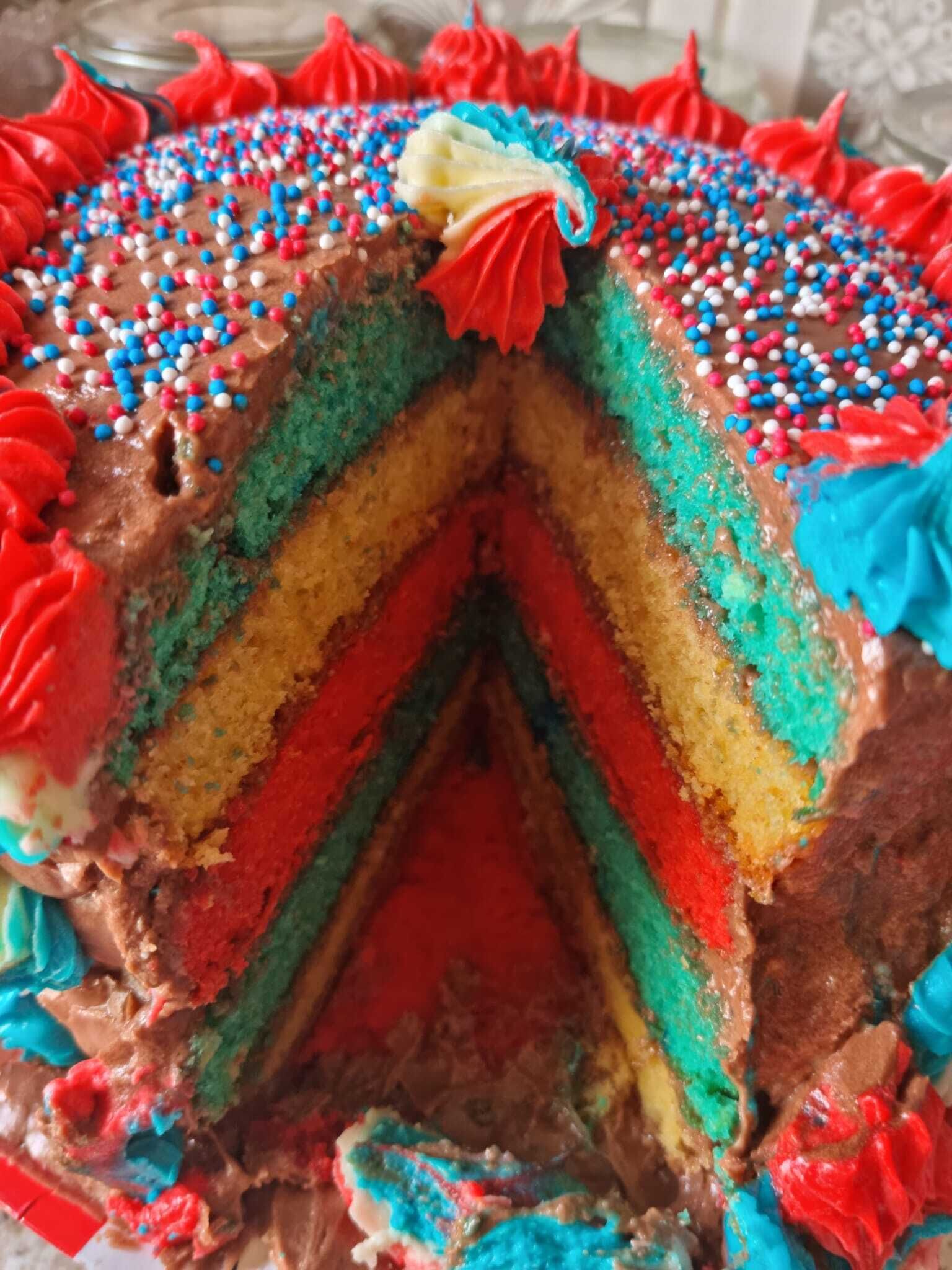 A multi-layered cake with colorful frosting and sprinkles.