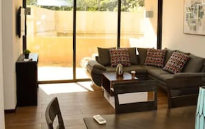 A modern living room with a sofa, coffee table, and a small side table.