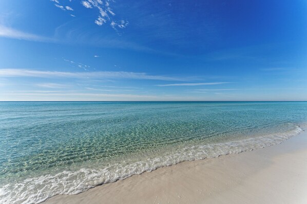 A beach with clear water and a sandy shore.