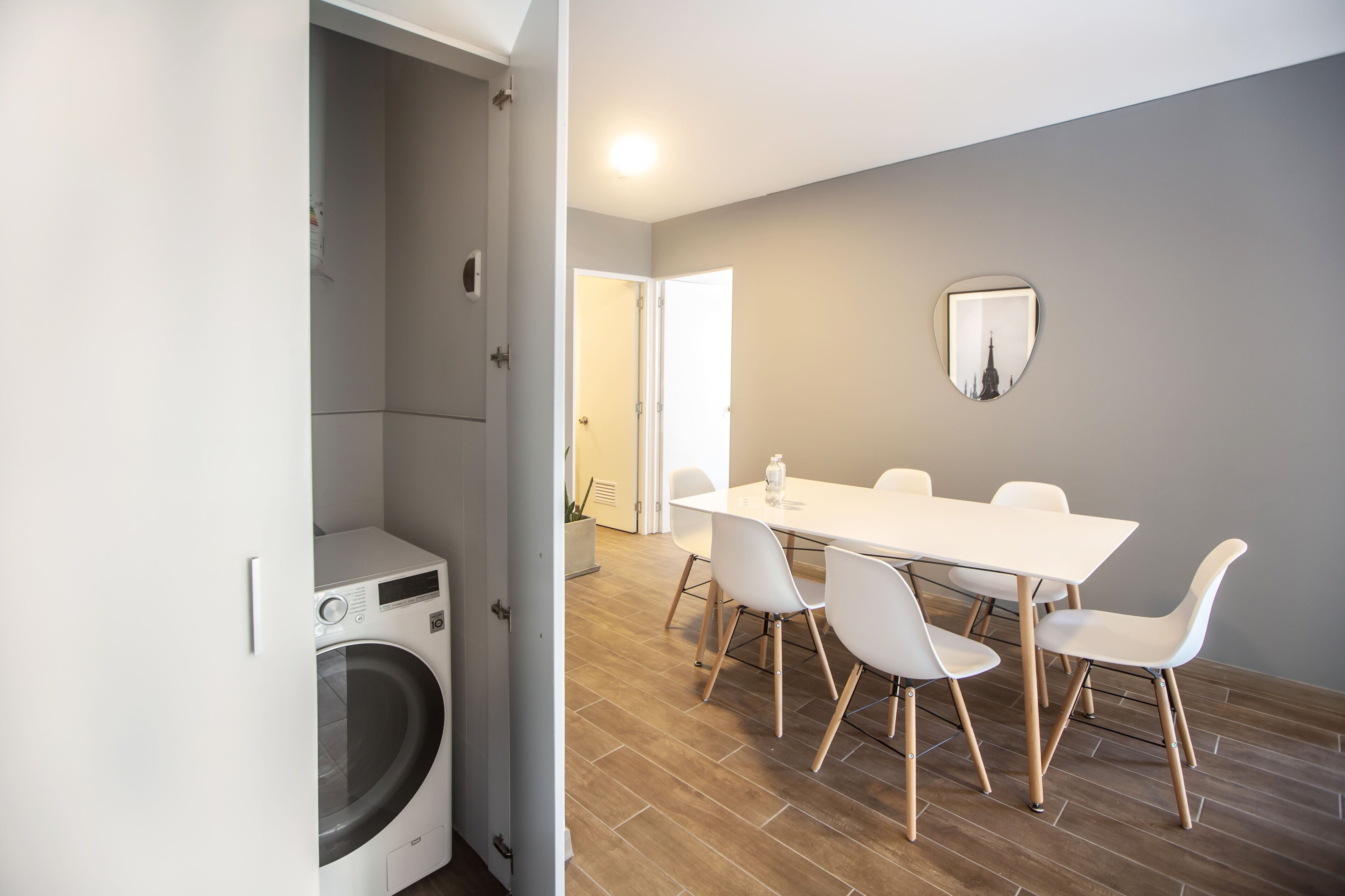 A modern kitchen with white appliances, a wooden countertop, and a dining area with a white table and chairs.
