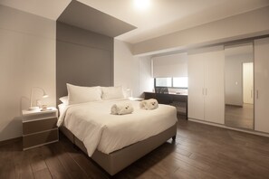 A modern bedroom with a large bed, bedside tables, a desk, and a wardrobe. - Soho Apartments in Miraflores by Wynwood-House (Lima)