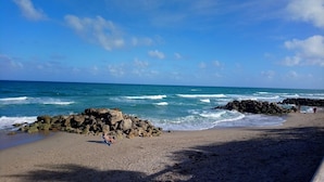 Une plage avec des formations rocheuses et des vagues.