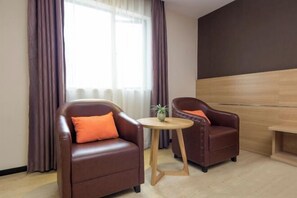 A modern room with two leather armchairs, a small wooden table, and a large window with curtains. - 7 Days Premiuml (Shenzhen Longgang Universiade Center Ailian subway station) (Shenzhen)
