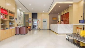 A hotel reception area with a marble counter, leather seating, and a reception desk. - 7 Days Premiuml (Shenzhen Longgang Universiade Center Ailian subway station) (Shenzhen)
