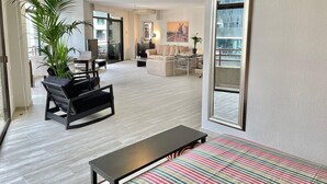 A spacious living area with a sofa, a coffee table, and a striped rug.
