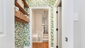 A hallway with patterned wallpaper, wooden flooring, and a staircase leading to another room. - ★Farmhouse Style★Outdoor Patios★Parking!★Beautiful (Pittsburgh)