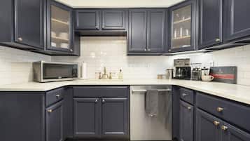 A kitchen with dark cabinets, a microwave, a coffee maker, and a dishwasher.