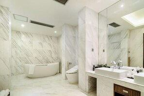 A modern bathroom with a freestanding bathtub, a toilet, and a vanity with a mirror. - Shehong Kuangyi Hotel (Yongyi Square) (Shehong)
