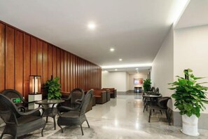 A lobby with a reception desk, seating area, and a television screen. - Shehong Kuangyi Hotel (Yongyi Square) (Shehong)