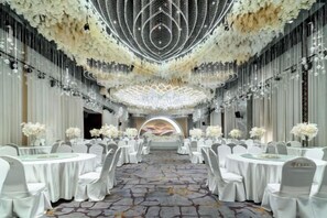 A banquet hall with round tables, white chairs, and a chandelier. - Shehong Kuangyi Hotel (Yongyi Square) (Shehong)