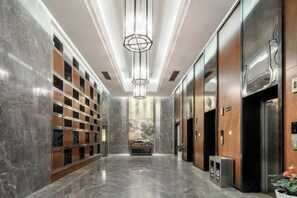 A modern hotel lobby with marble floors, a central chandelier, and a reception desk. - Shehong Kuangyi Hotel (Yongyi Square) (Shehong)