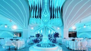 A modern, well-lit venue with a central stage, tiered seating, and a symmetrical design. - Shehong Kuangyi Hotel (Yongyi Square) (Shehong)