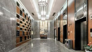 A modern elevator lobby with marble flooring, a central light fixture, and a row of elevators on the right. - Shehong Kuangyi Hotel (Yongyi Square) (Shehong)