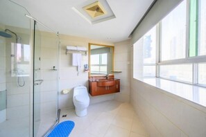 A modern bathroom with a glass shower enclosure, a white toilet, and a wooden vanity with a mirror. - Sunny Holiday Hotel (Shishi)