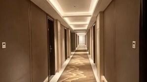 A long, narrow hotel corridor with a patterned carpet and recessed lighting. - Sunny Holiday Hotel (Shishi)