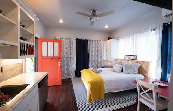 A bedroom with a bed, bedside table, and a red wardrobe.