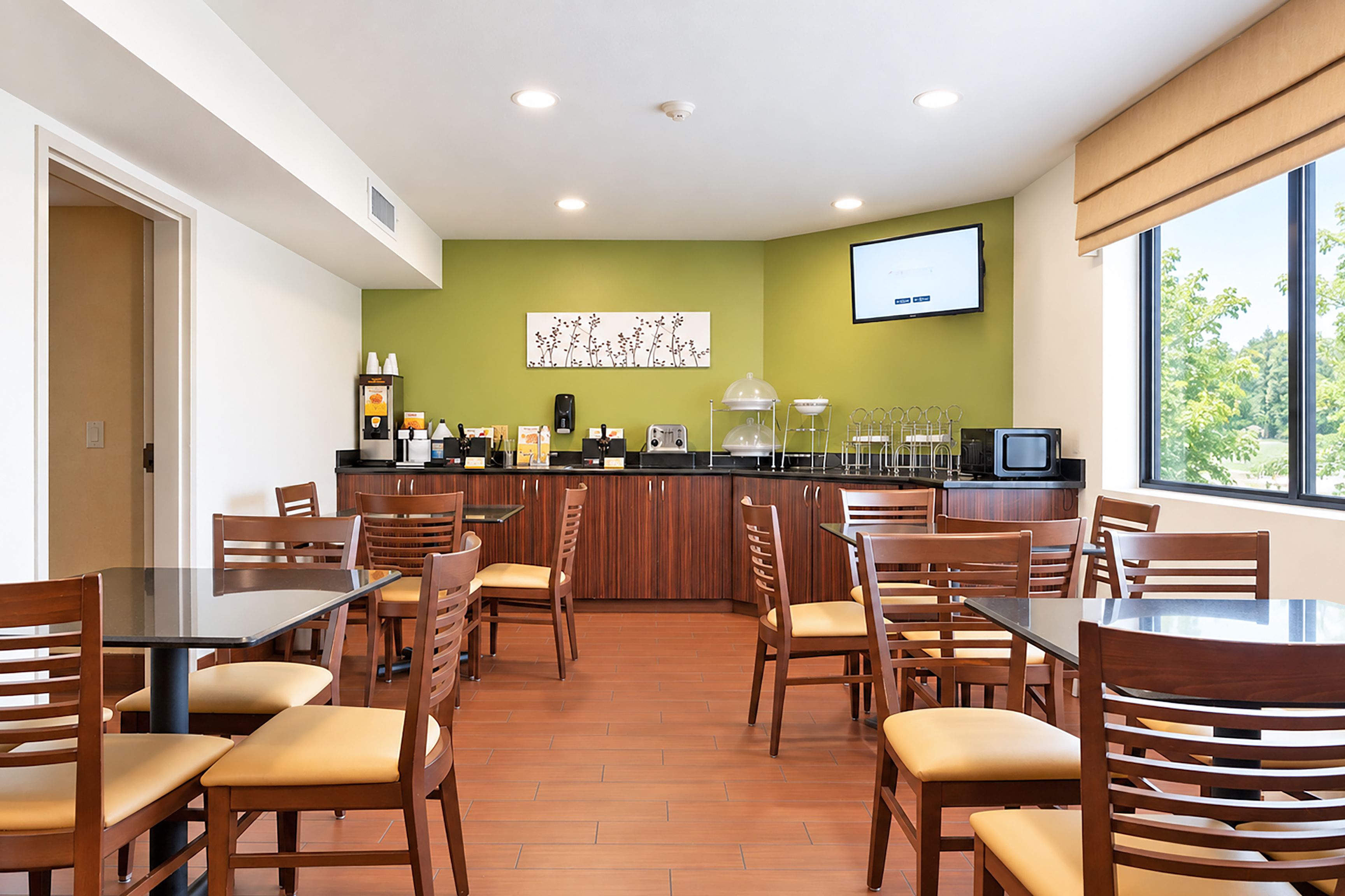 Un ristorante con un bancone, sedie e un televisore.