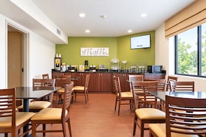 Um restaurante com balcão, cadeiras e televisão.