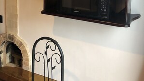 Una cocina con microondas integrado, un jarrón decorativo y una ventana con vistas a la vegetación.