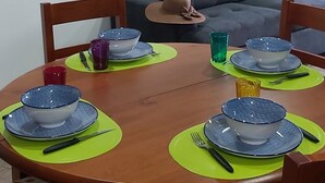 A dining table set with blue and white bowls, plates, and cutlery, surrounded by chairs with patterned cushions. - Typical house in the heart of the Douro (Casal de Loivos)