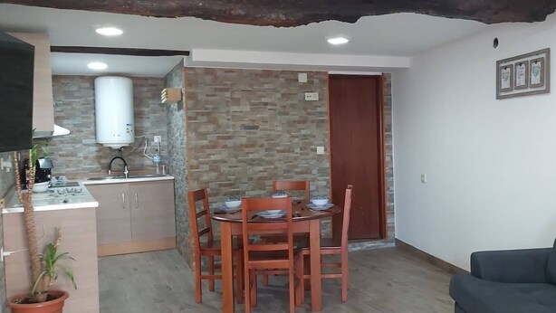 A compact living space with a kitchenette, dining area, and a sofa. - Typical house in the heart of the Douro (Casal de Loivos)