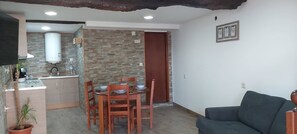 A compact living space with a kitchenette, dining area, and a sofa. - A traditional house in the heart of the Douro (Casal de Loivos)