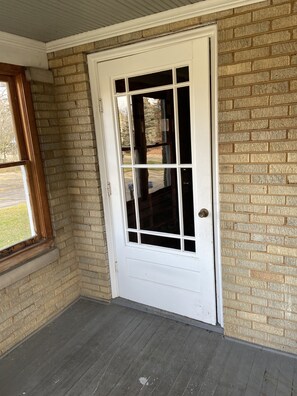 Enjoy a cozy retreat in this corner room with a brick wall, wooden window frame, and dark wooden planks.